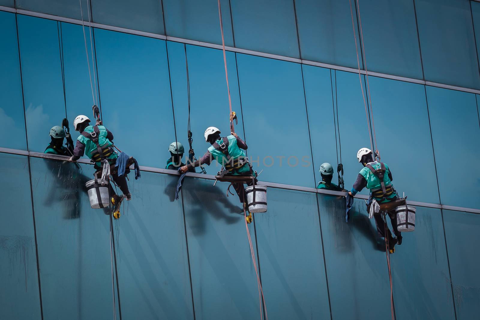 group of workers cleaning windows service on high rise building