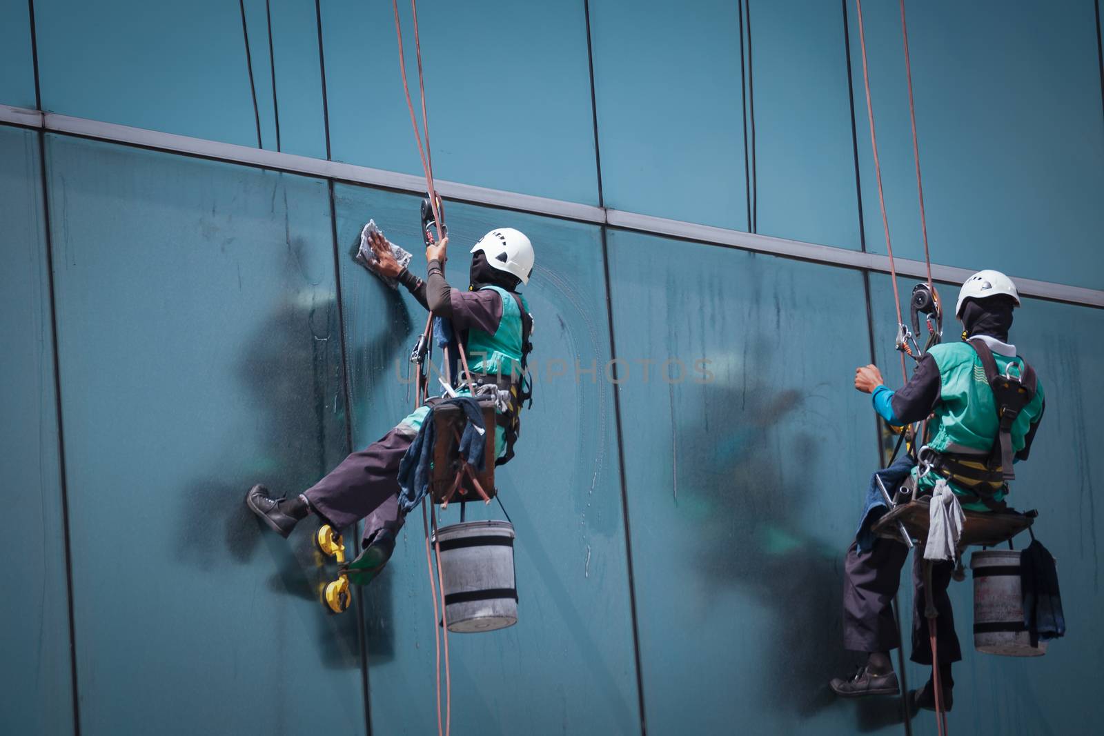 group of workers cleaning windows service on high rise building