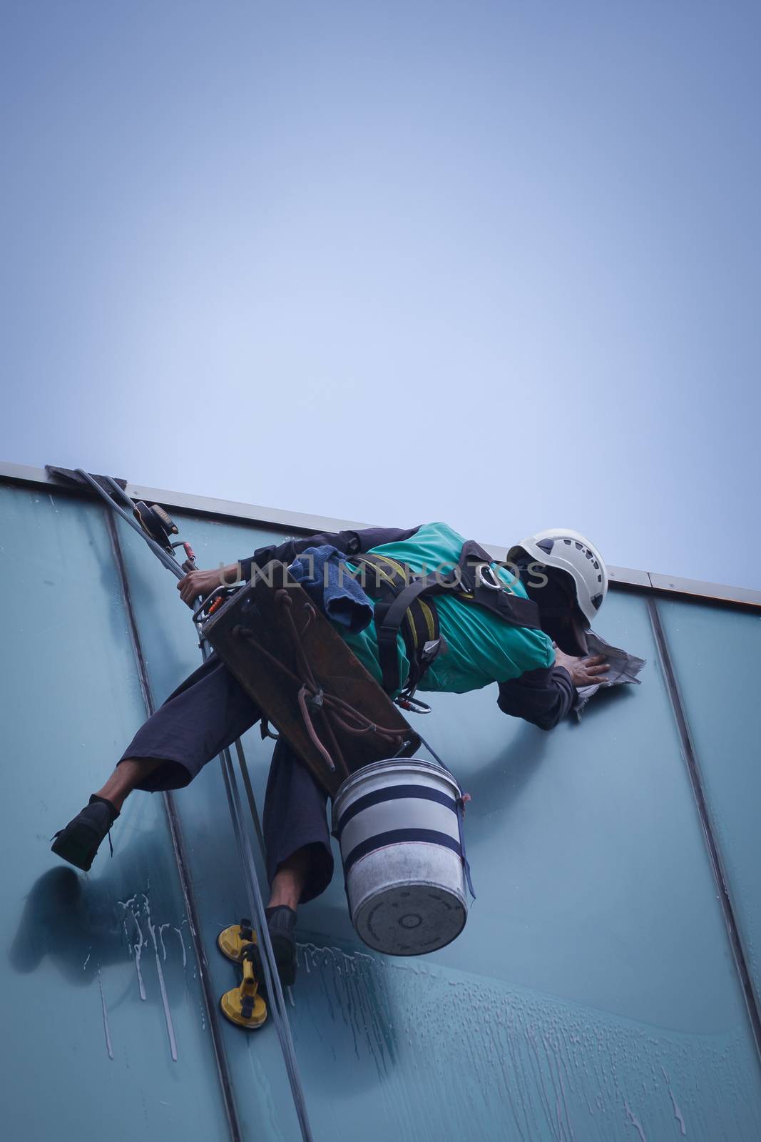 group of workers cleaning windows service on high rise building