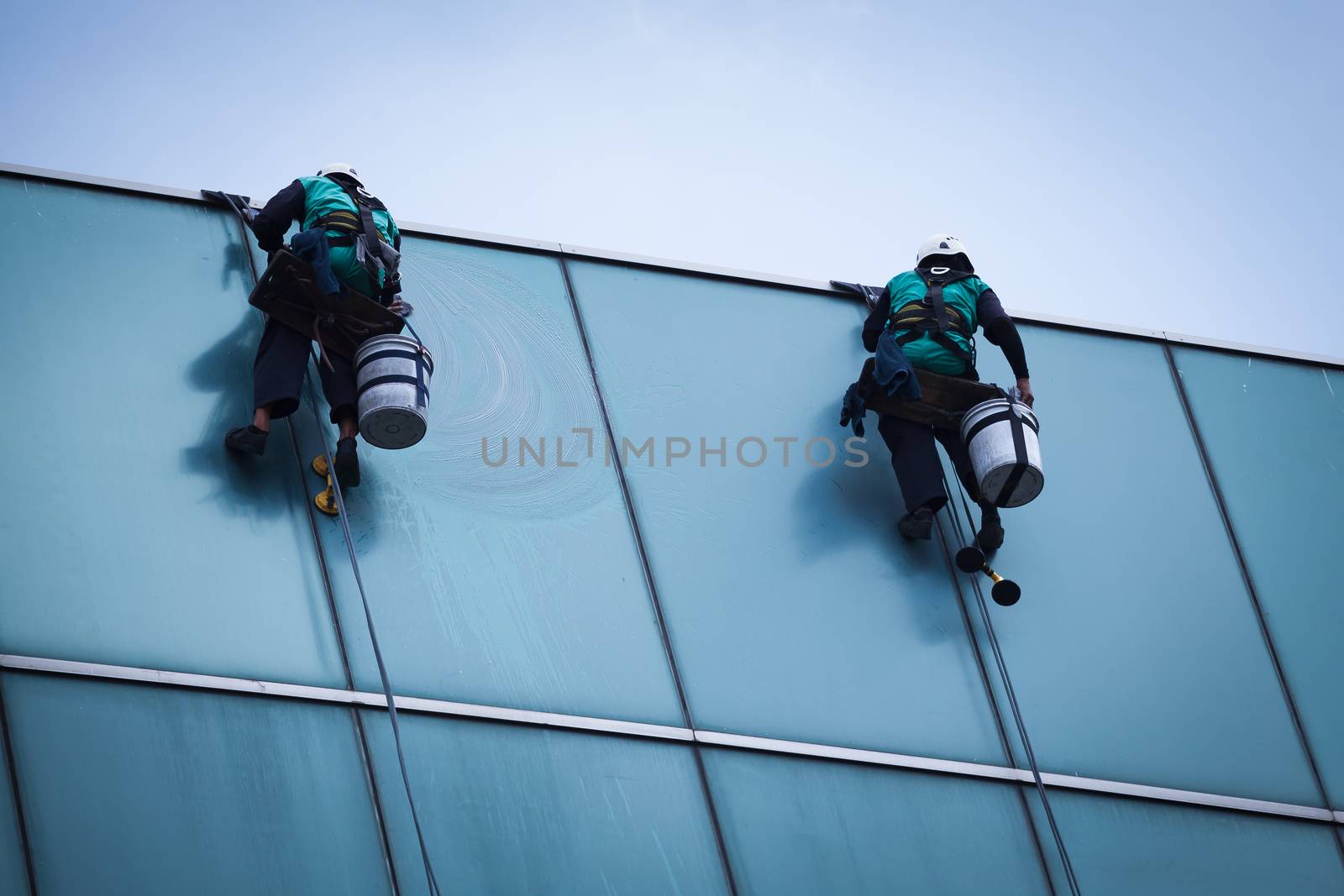 group of workers cleaning windows service on high rise building