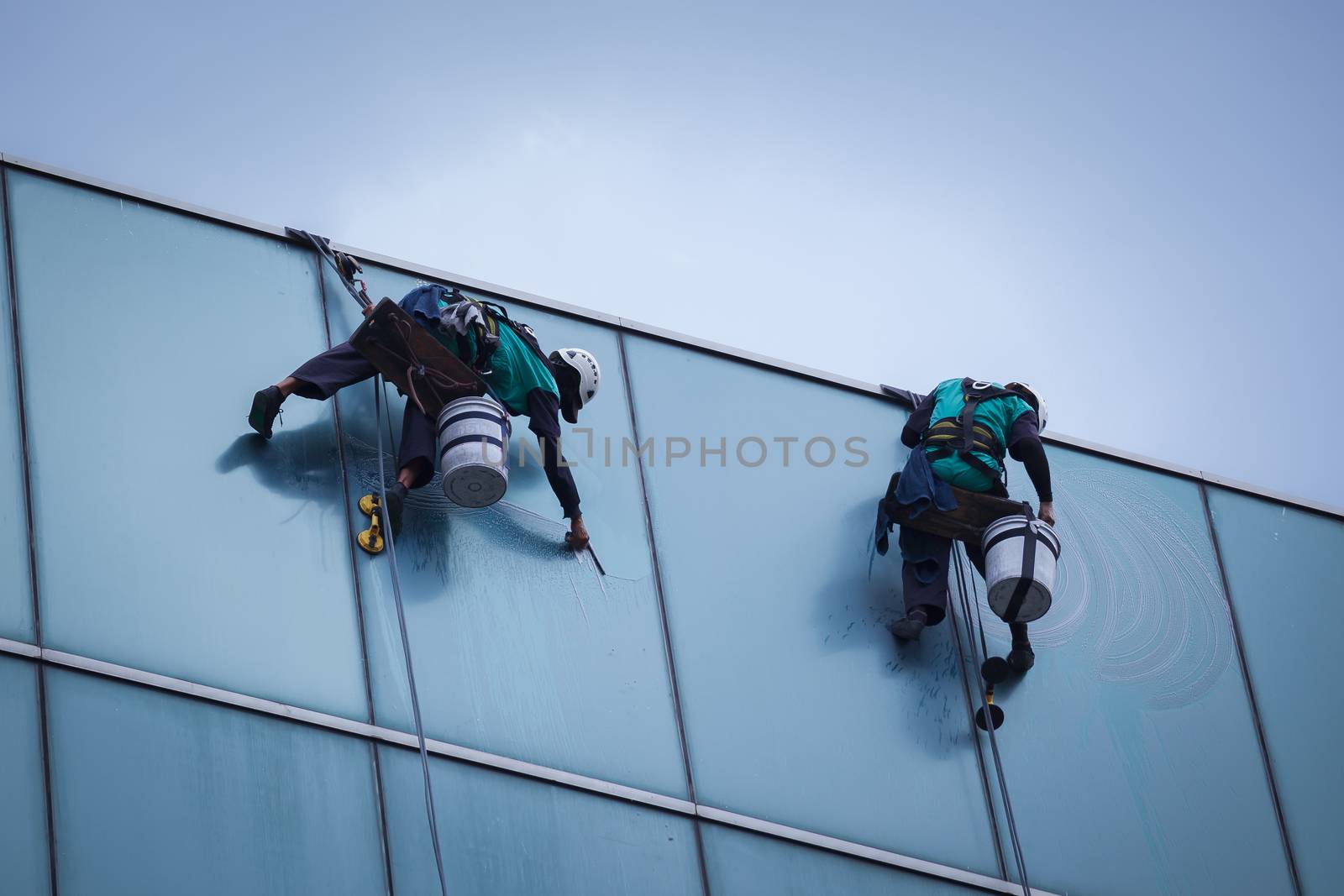 group of workers cleaning windows service on high rise building