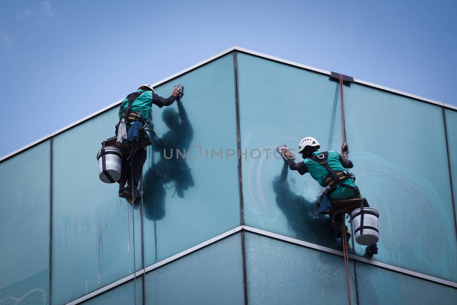 group of workers cleaning windows service on high rise building
