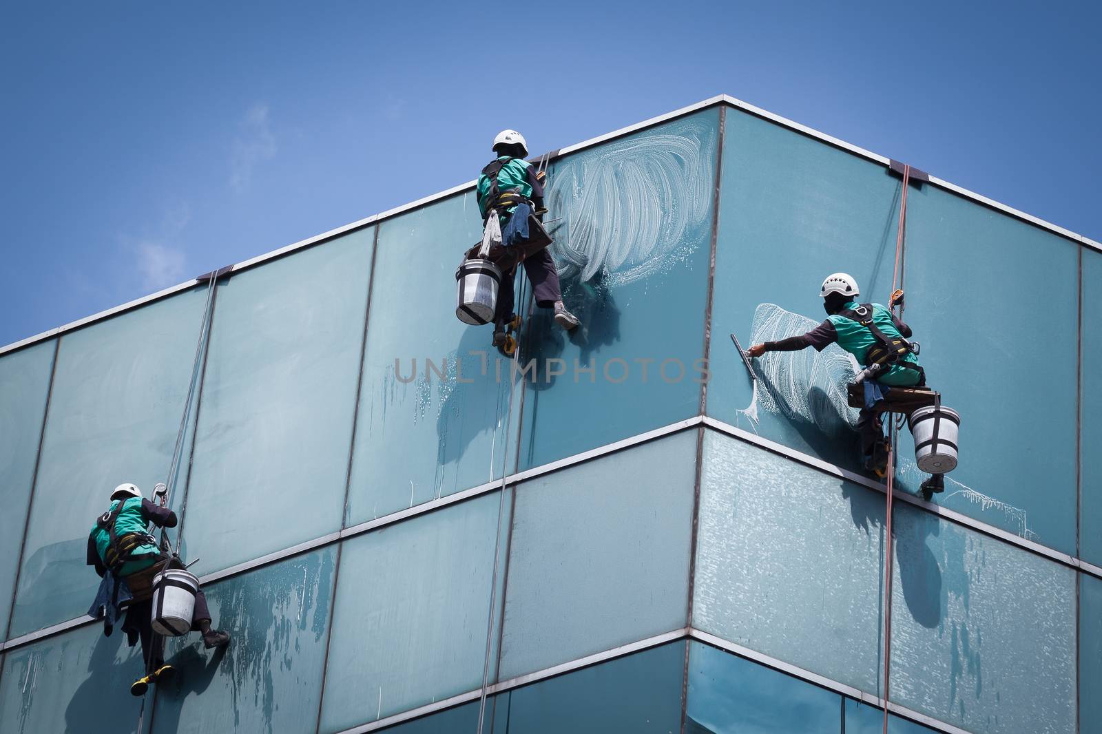 group of workers cleaning windows service on high rise building