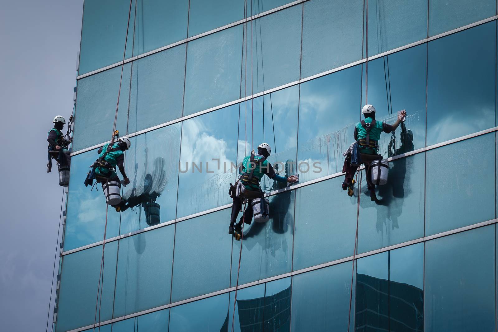 group of workers cleaning windows service on high rise building