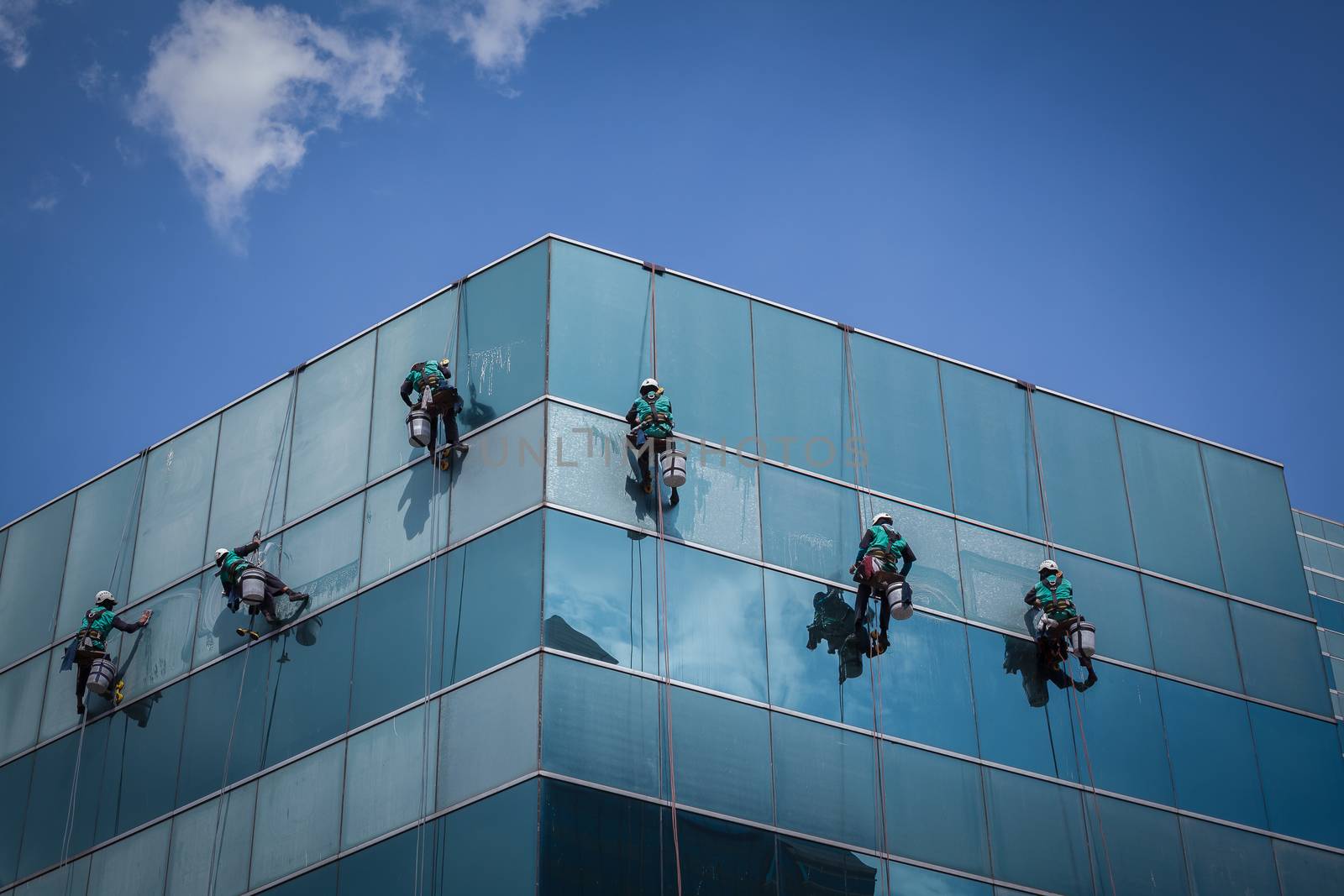 group of workers cleaning windows service on high rise building