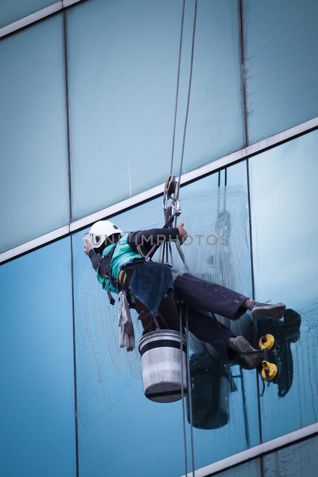 group of workers cleaning windows service on high rise building