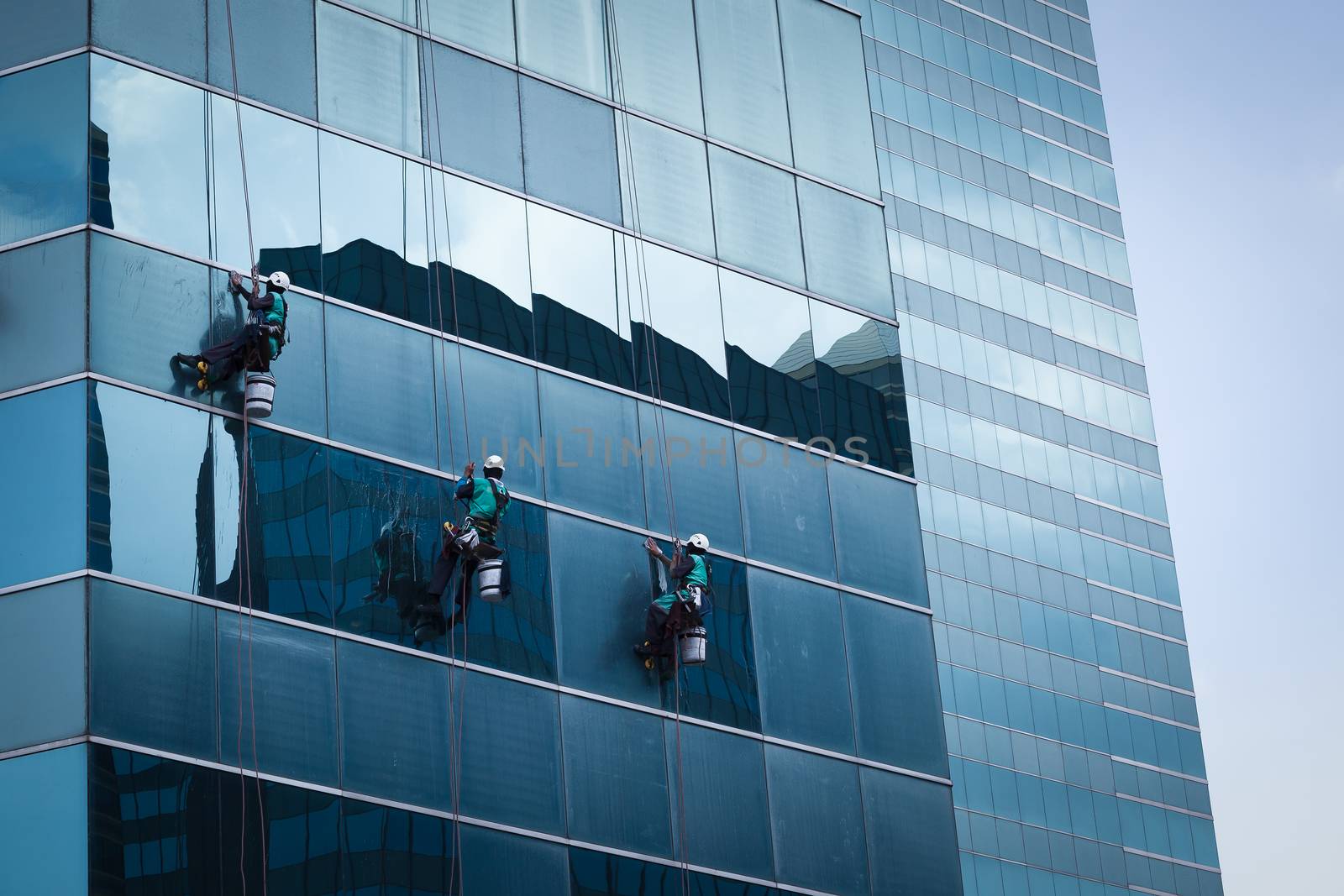 group of workers cleaning windows service on high rise building