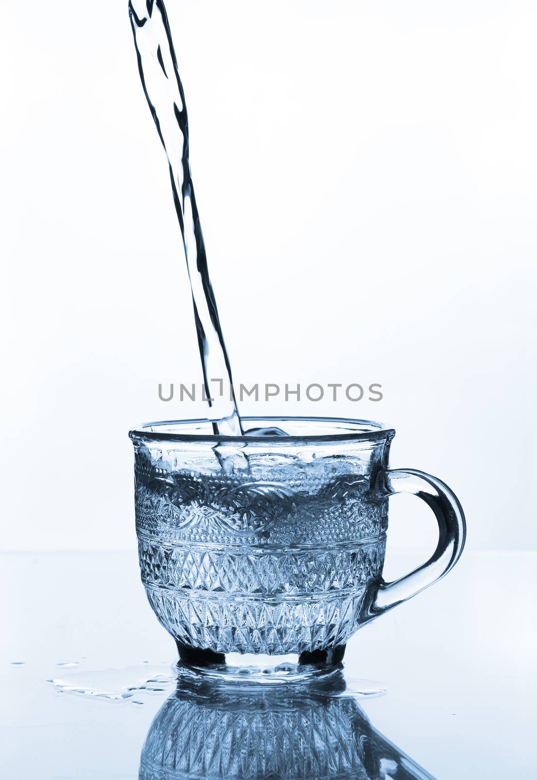 cup glass with water pouring on glass table