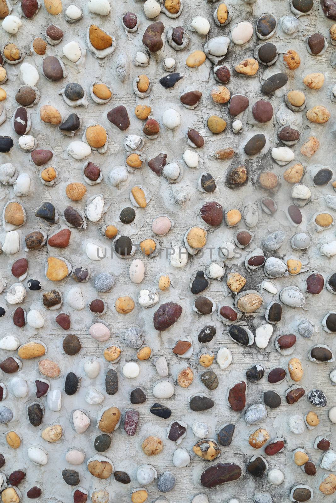 Pebbles in concrete wall texture background