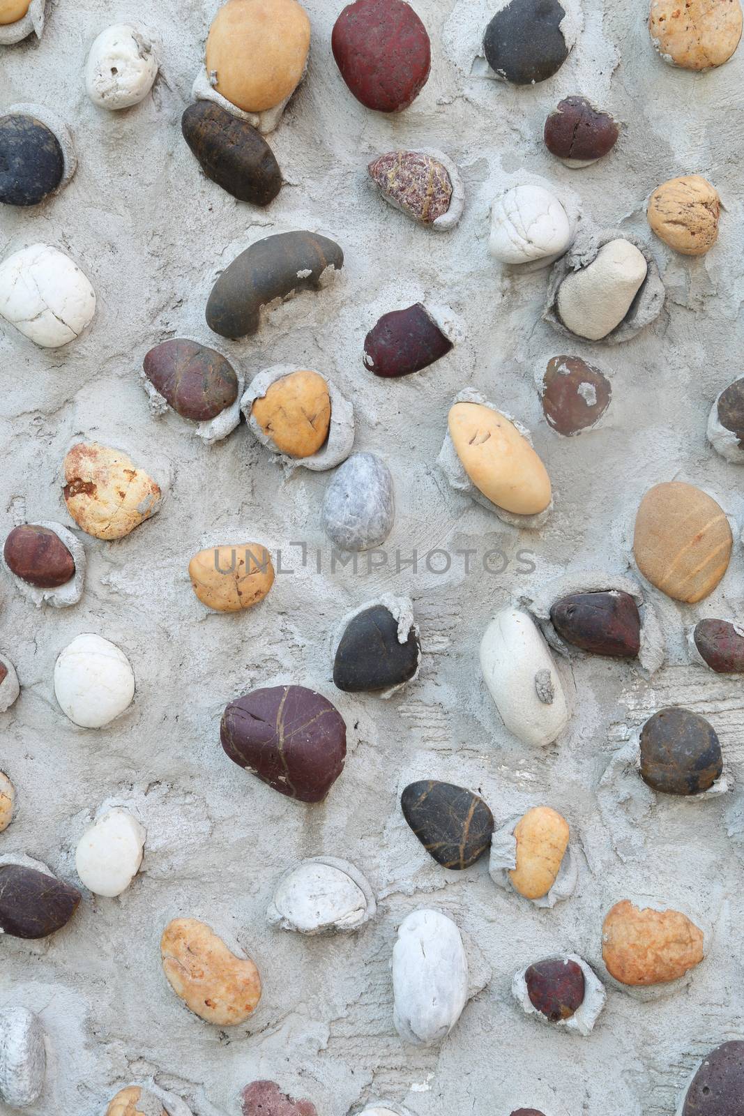 Pebbles in concrete wall texture background