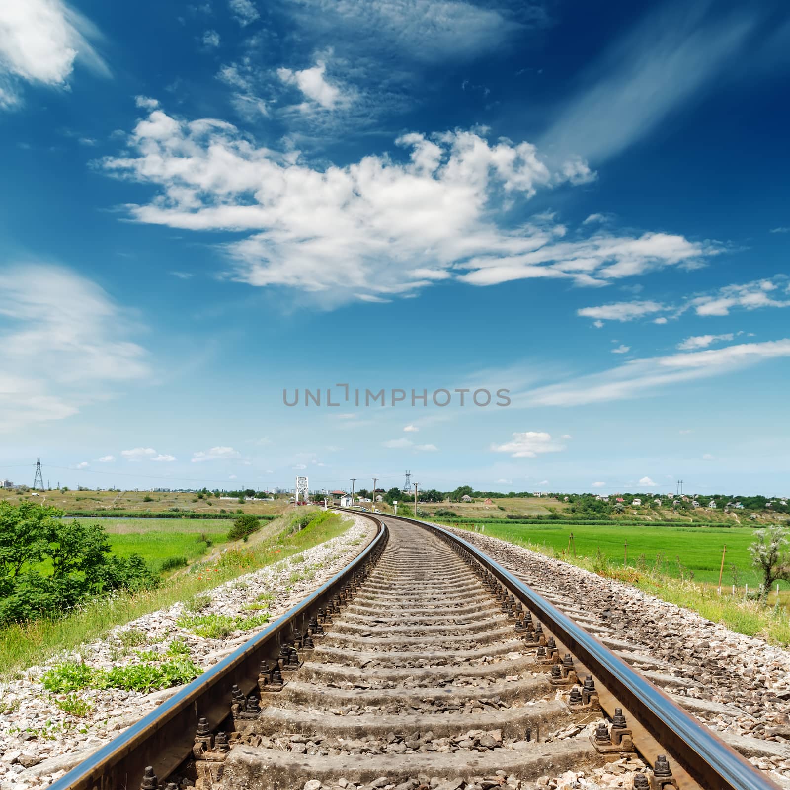rail road to horizon under deep blue sky by mycola