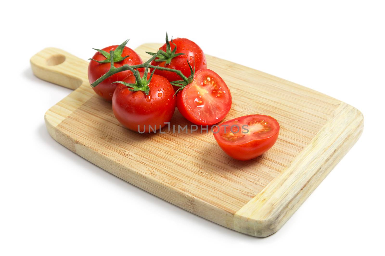 Fresh tomatoes on wooden chopping board   by Elisanth
