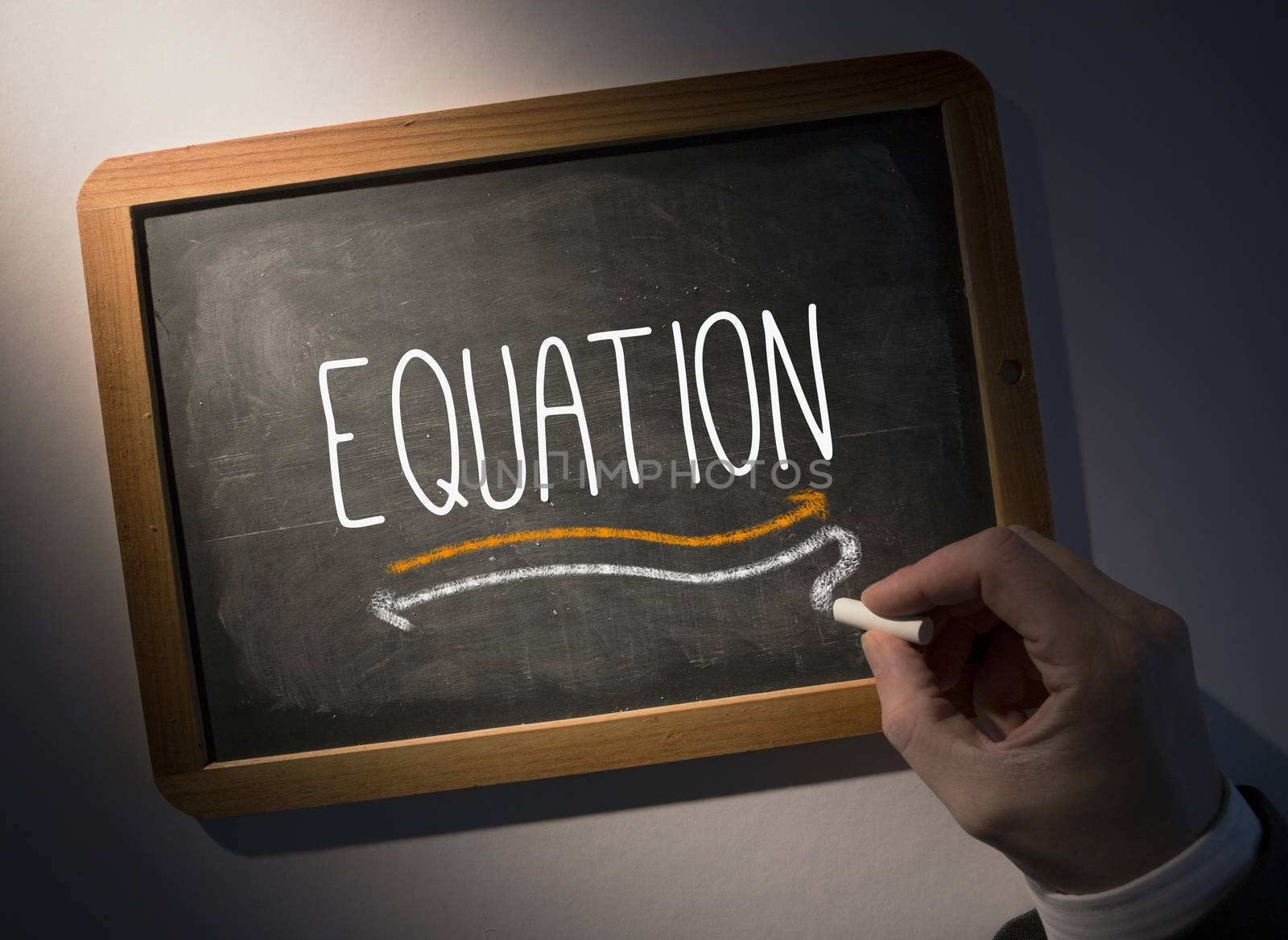 Hand writing Equation on chalkboard by Wavebreakmedia