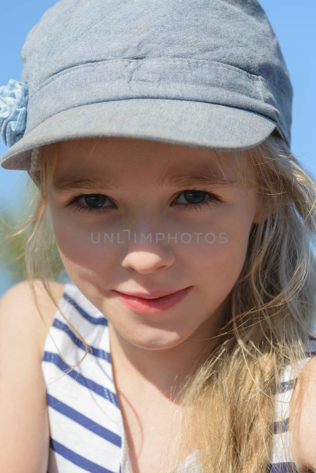 Portrait of a beautiful blonde little girl in denim hat