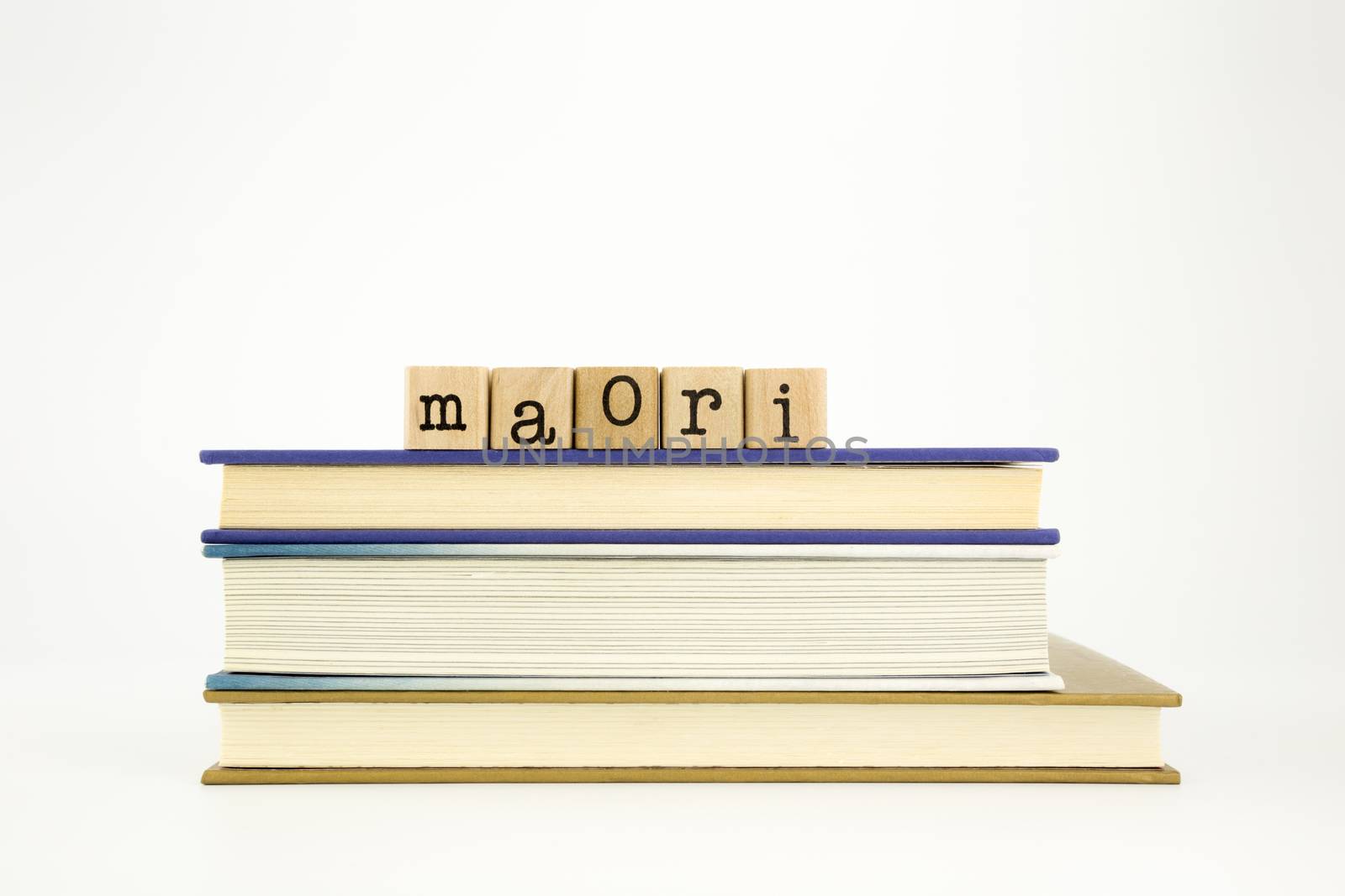 maori word on wood stamps stack on books, academic and language concept