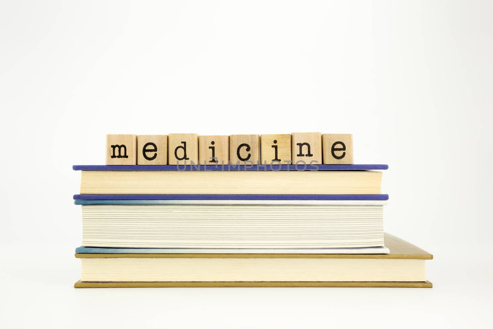 medicine word on wood stamps stack on books, academic and study concept