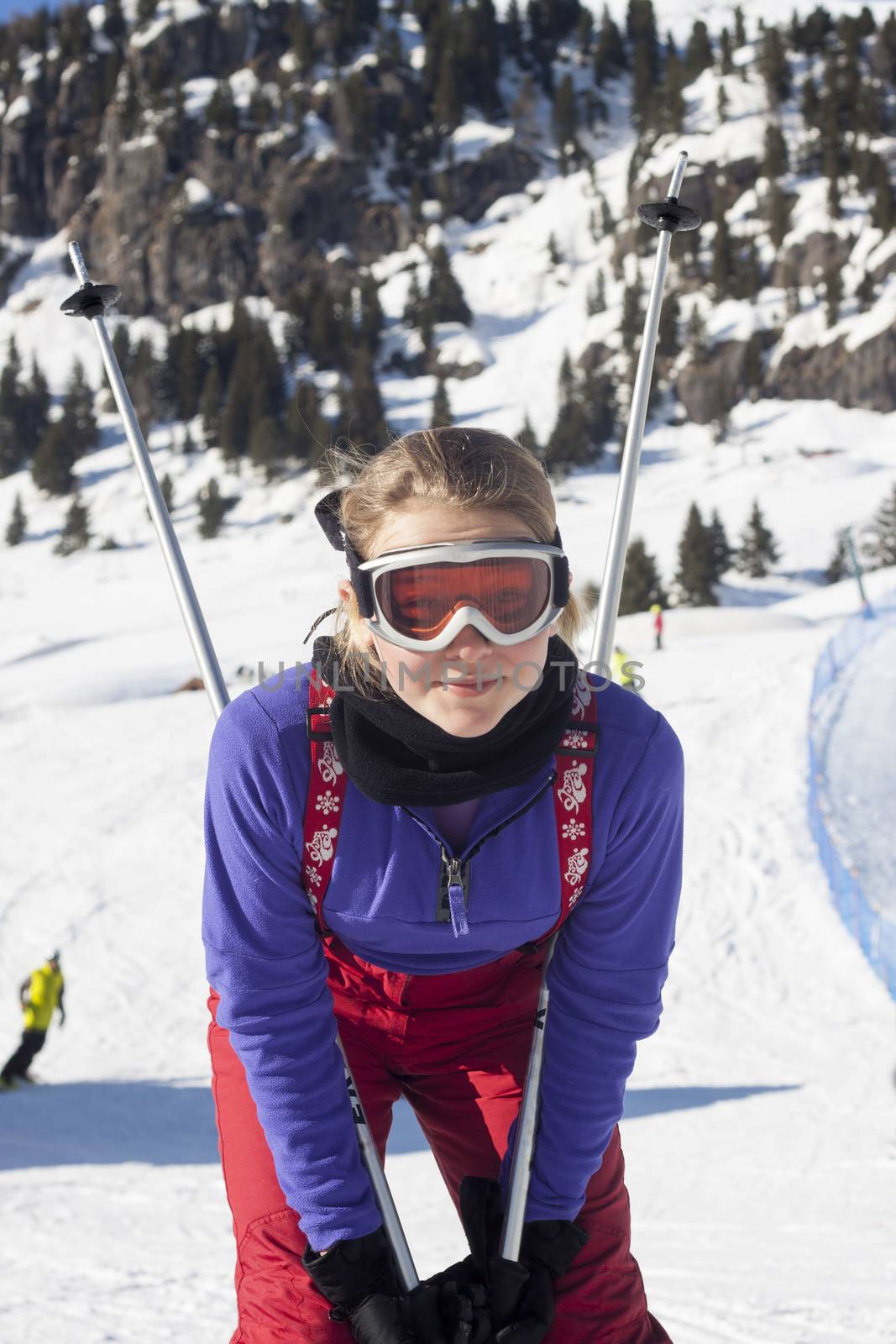 Child with ski poles in the skiing slopes