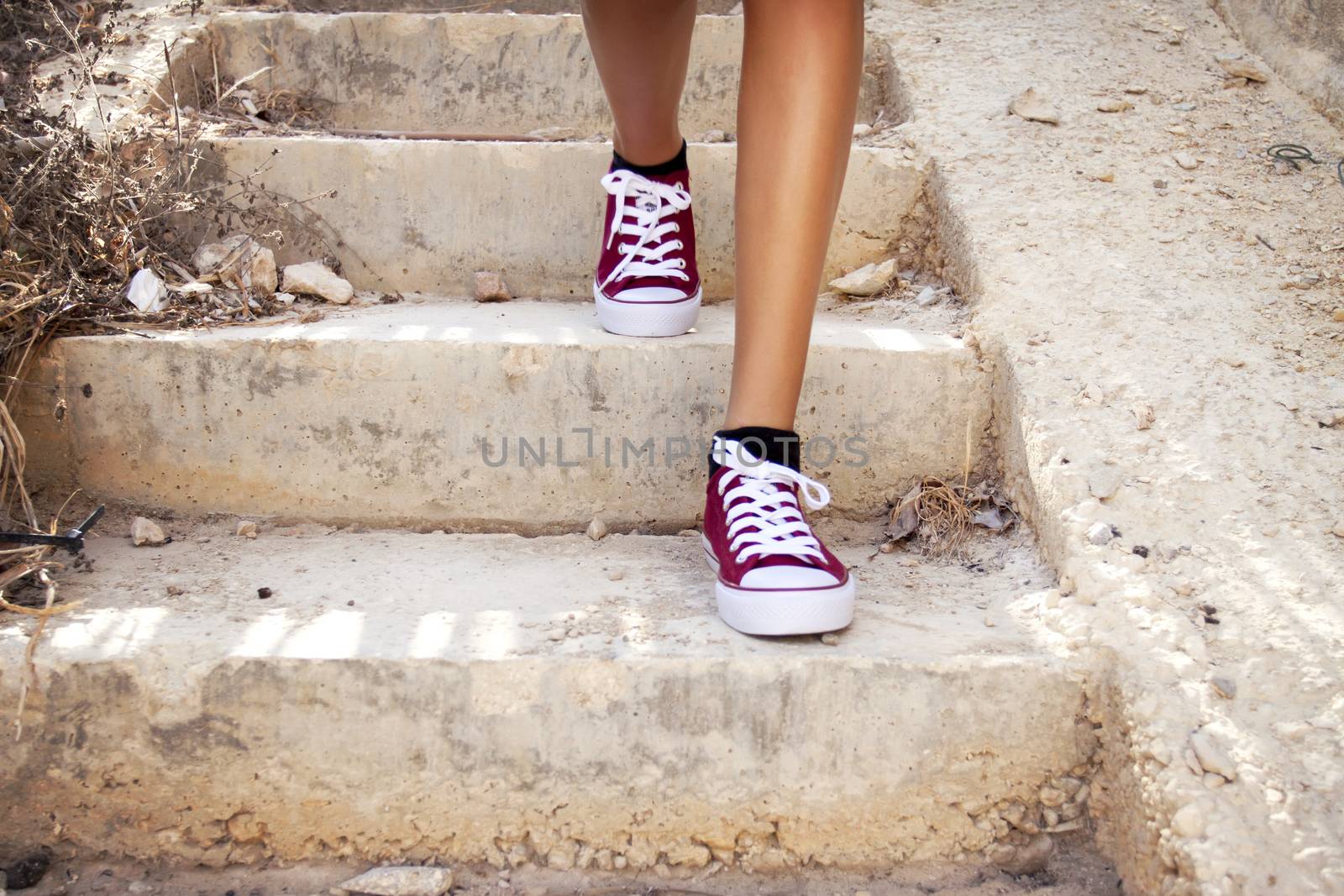Barelegs with red sneakers walking in stairs by annems