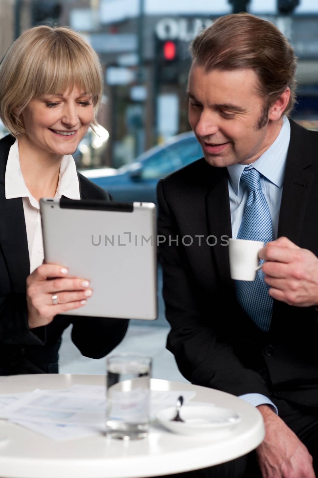 Cheerful business people using digital tablet  by stockyimages