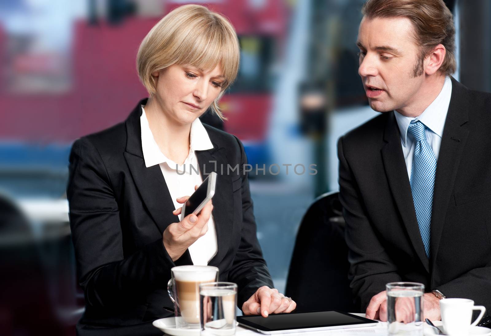 Business people having discussion at cafe by stockyimages