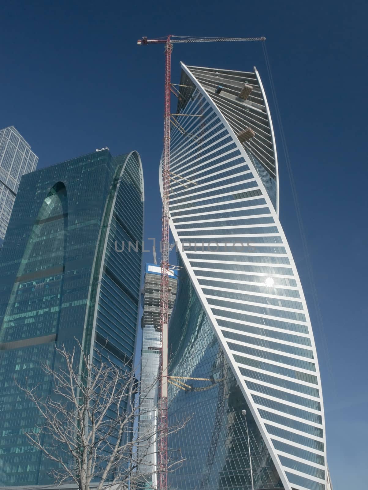 Tower office building under construction with elevating crane