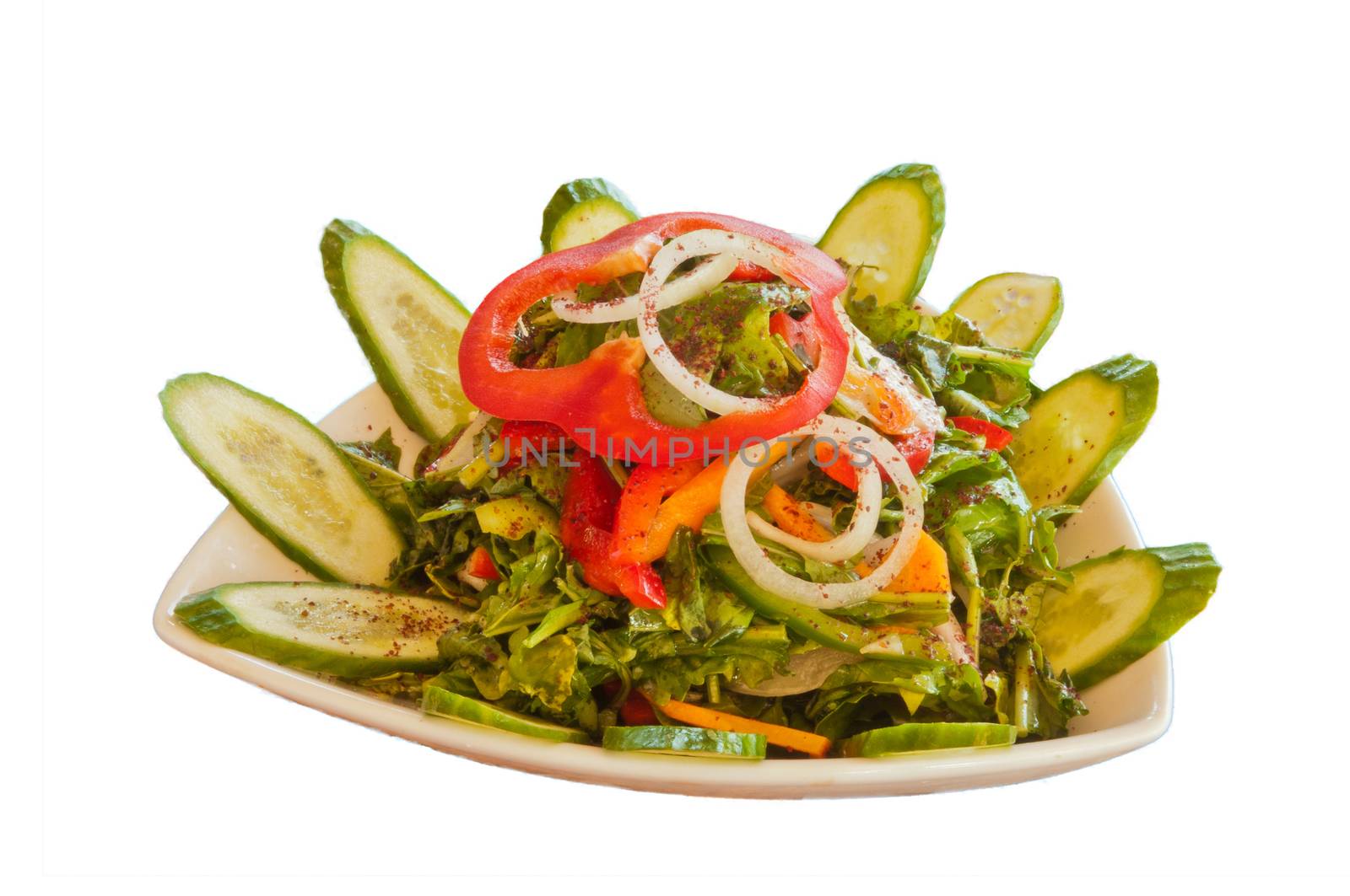 Salad greens and cucumbers garnished with onion rings and Bulgarian red pepper