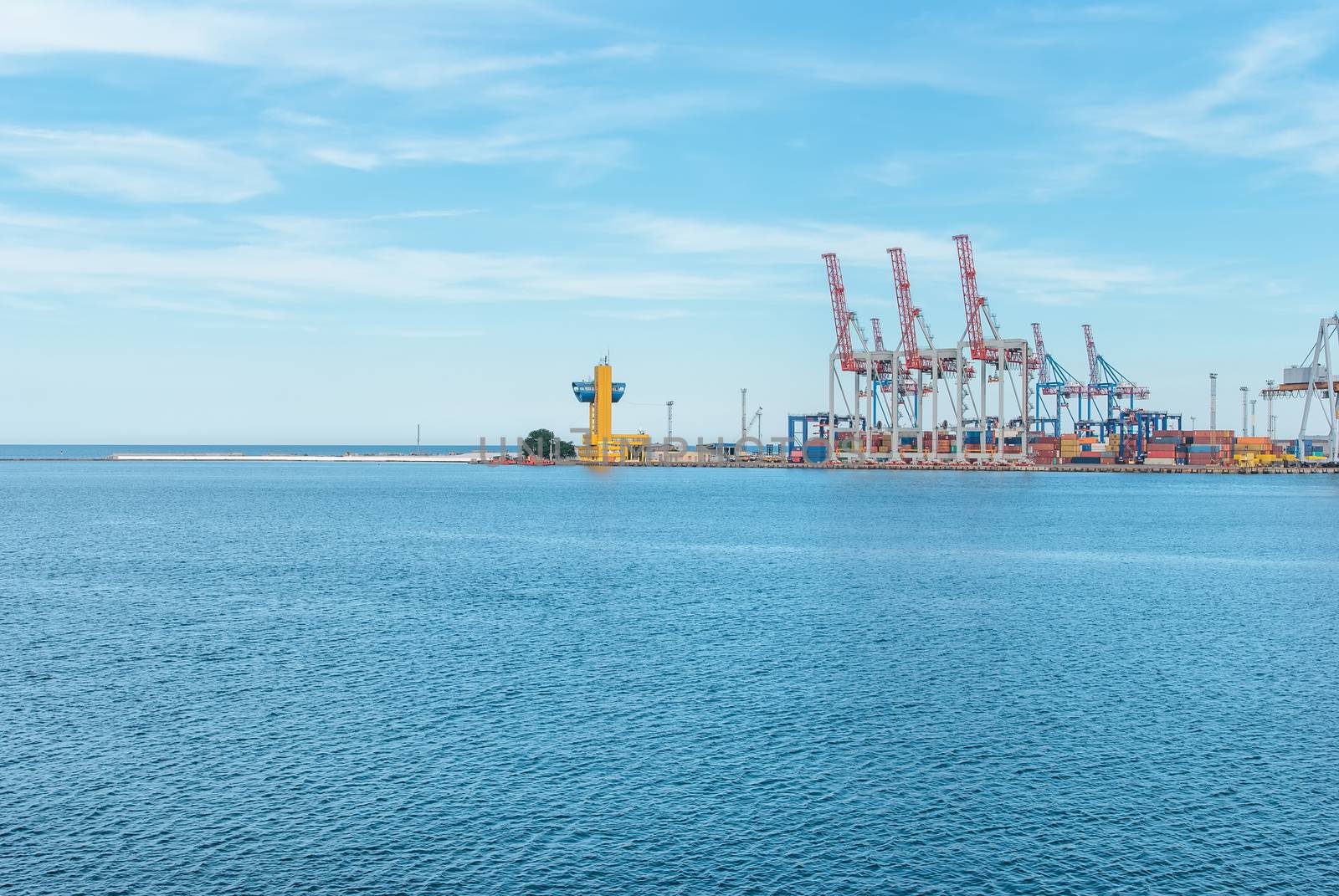 Port cargo crane and container over blue sky background