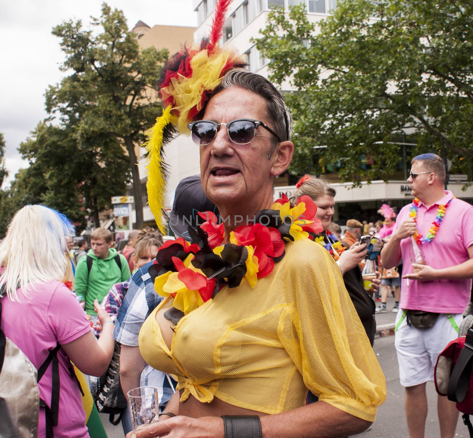 BERLIN, GERMANY - JUNE 21, 2014: Christopher Street Day.Crowd of people Participate in the parade celebrates gays, lesbians, bisexuals and transgenders.Prominent in the image a senior male man with big breasts.