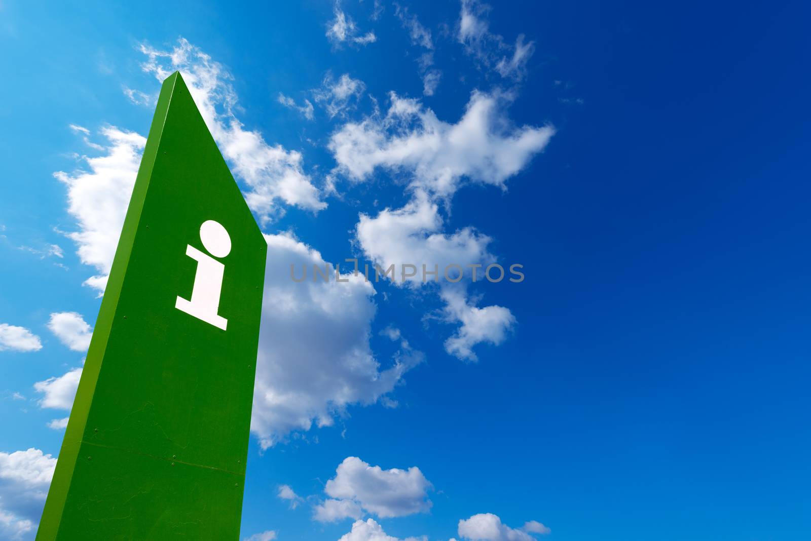 Green billboard with symbol of tourist information on blue sky with clouds - Barceloneta beach in Barcelona, Spain