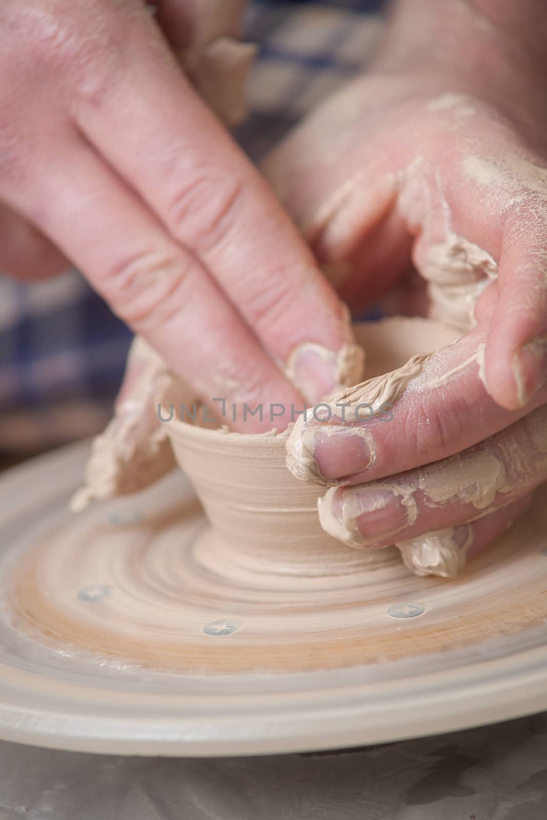 Hands of a potter, creating an earthen jar on the circle