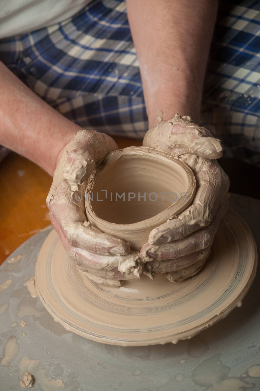 Hands of a potter, creating an earthen jar on the circle