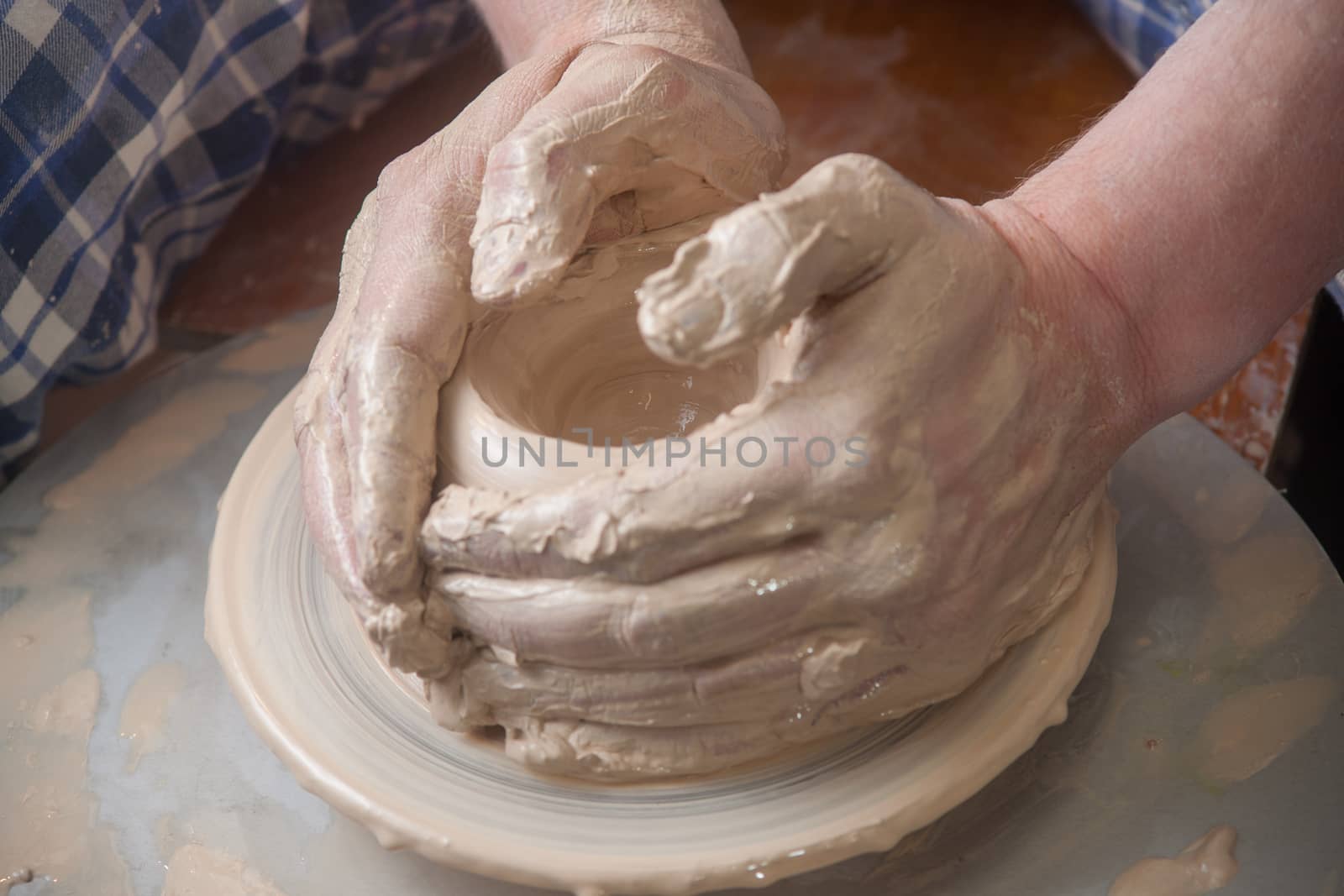 Hands of a potter, creating an earthen jar on the circle