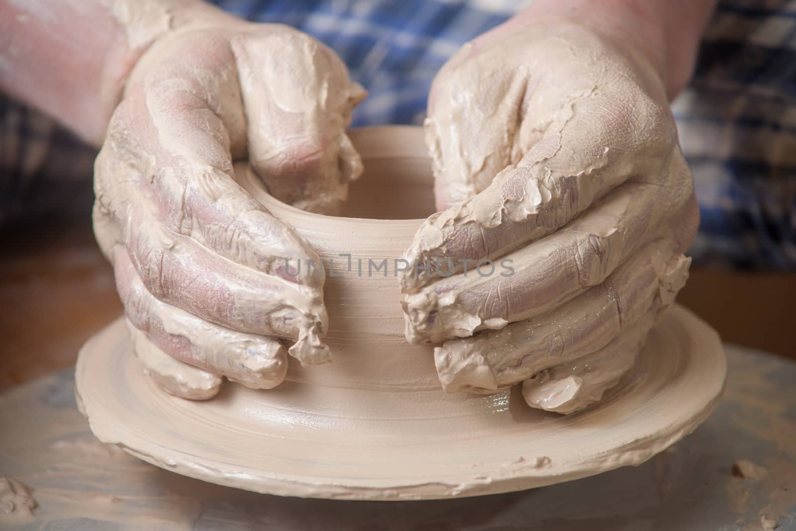 Hands of a potter, creating an earthen jar on the circle