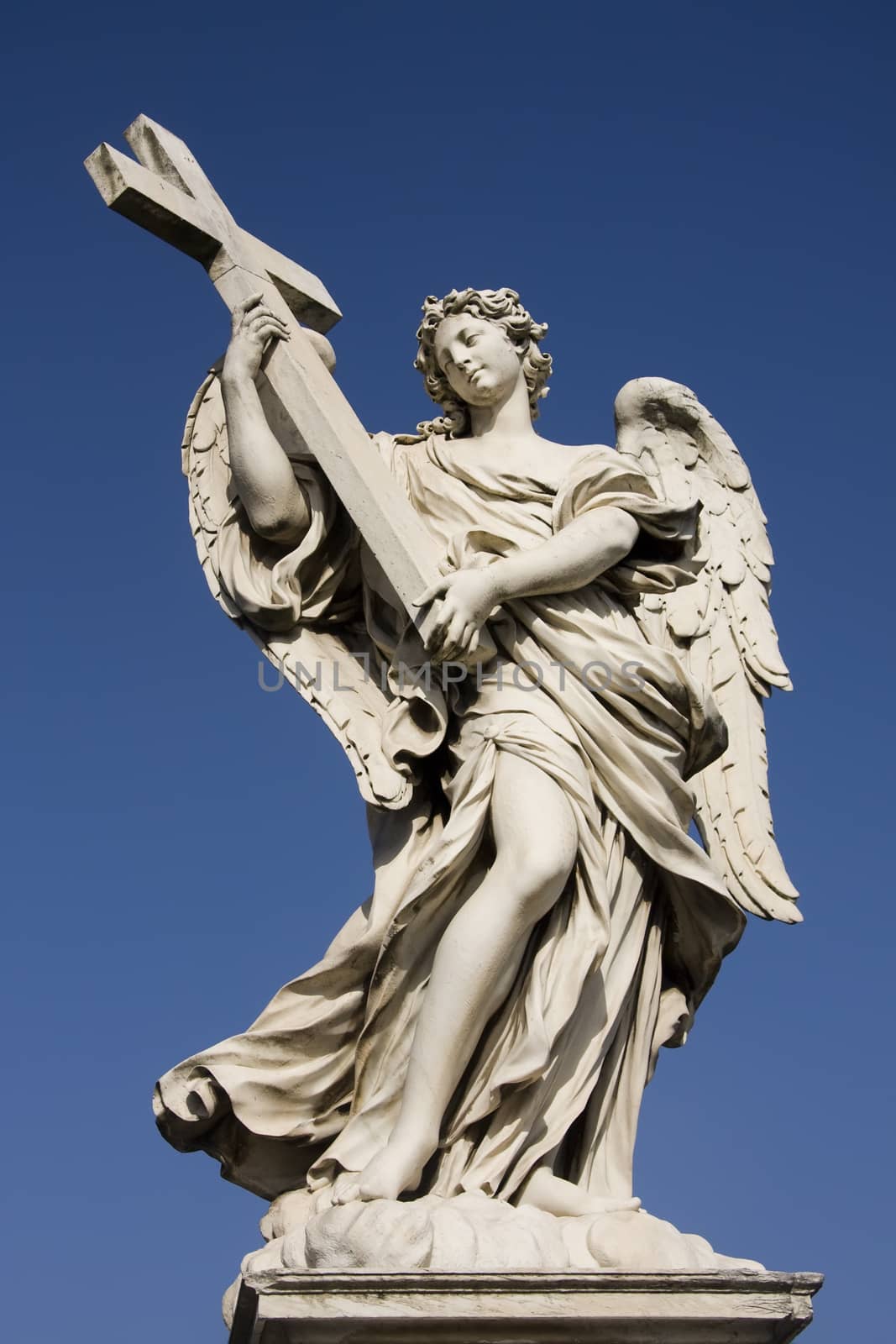 Statue of an angel holding a cross on the Sant Angelo Bridge in Rome, Italy