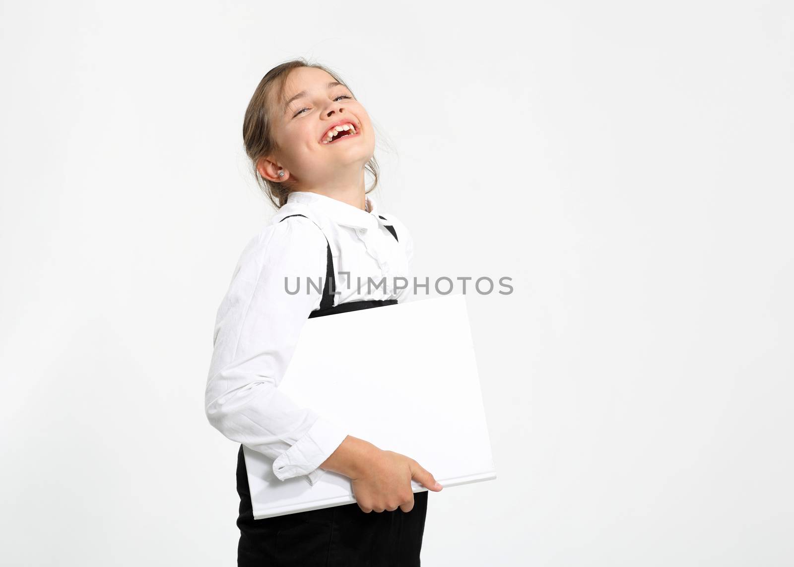 Girl in school uniform on a white background with a textbook in hand