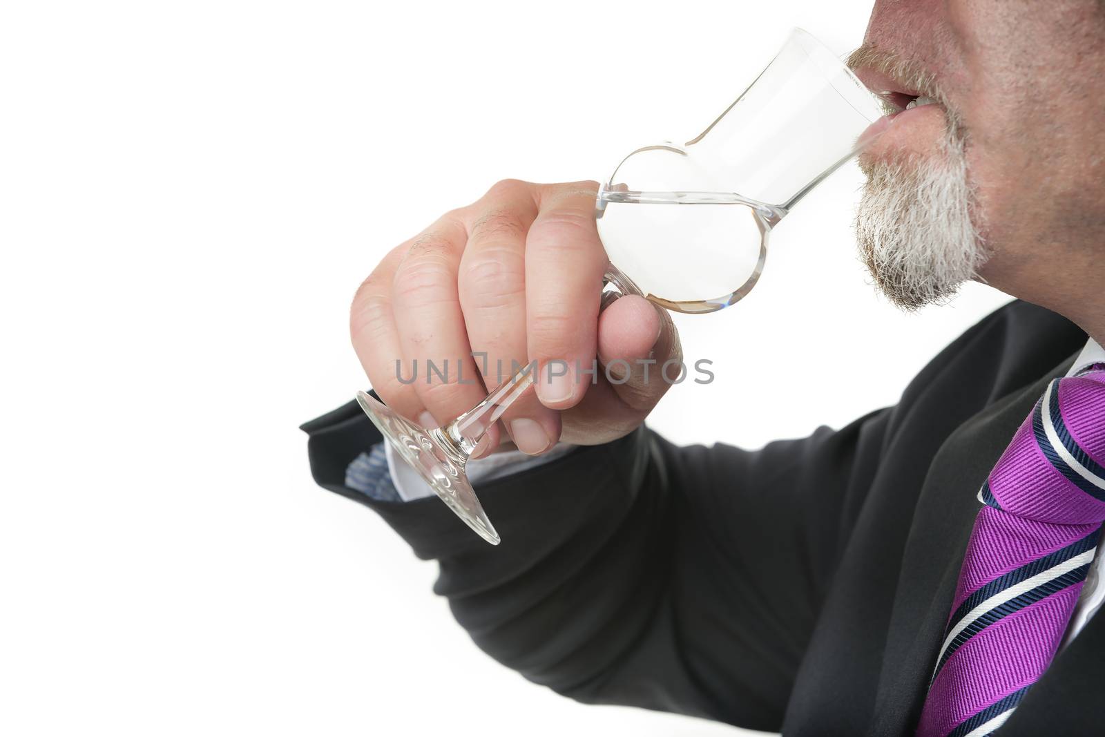 Business man in dark suite with a grappa glas is drinking alcohol