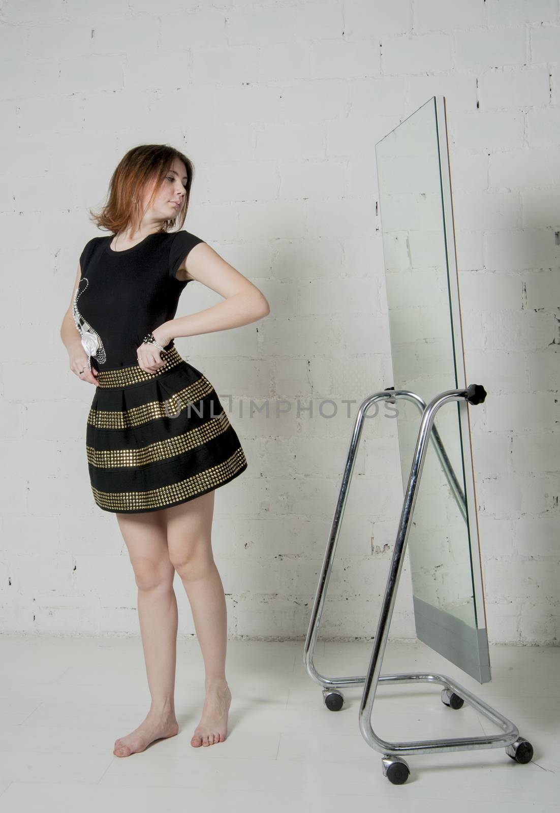 young woman tries on a new dress before the mirror