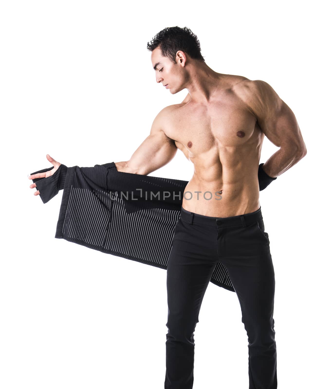 Handsome muscular young man taking off shirt, isolated on white