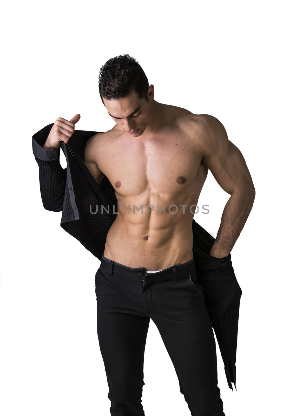 Handsome muscular young man taking off shirt, isolated on white, looking down