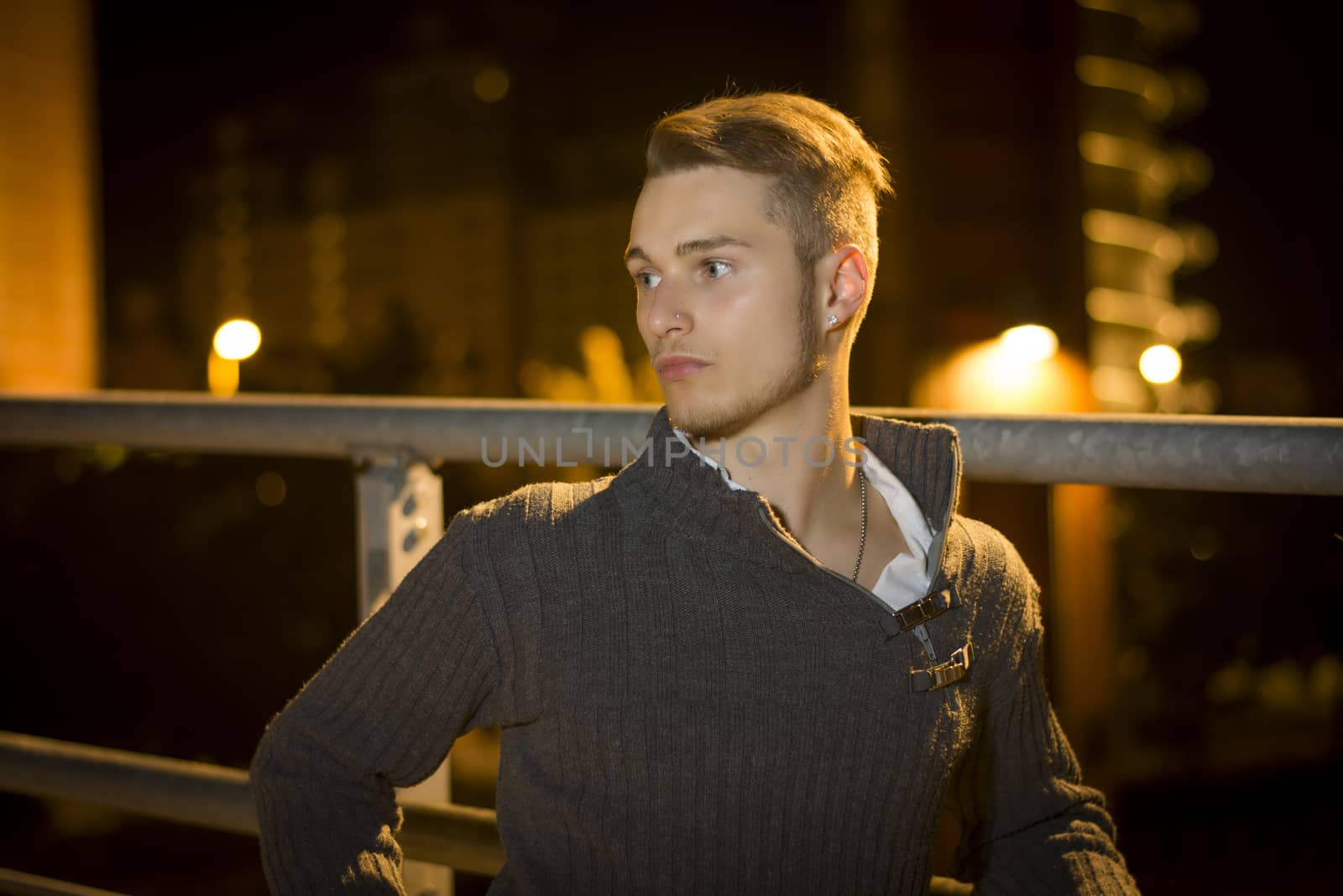 Handsome blond young man alone in urban setting by artofphoto