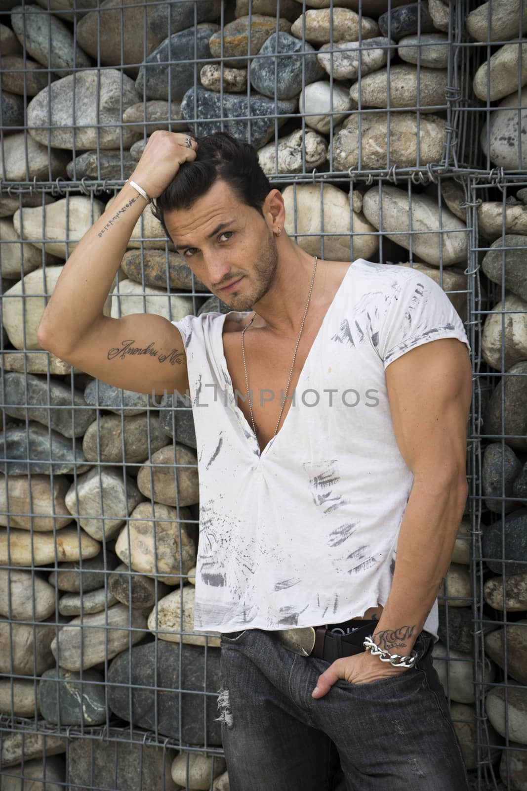 Handsome man outdoor in front of stone wall  by artofphoto