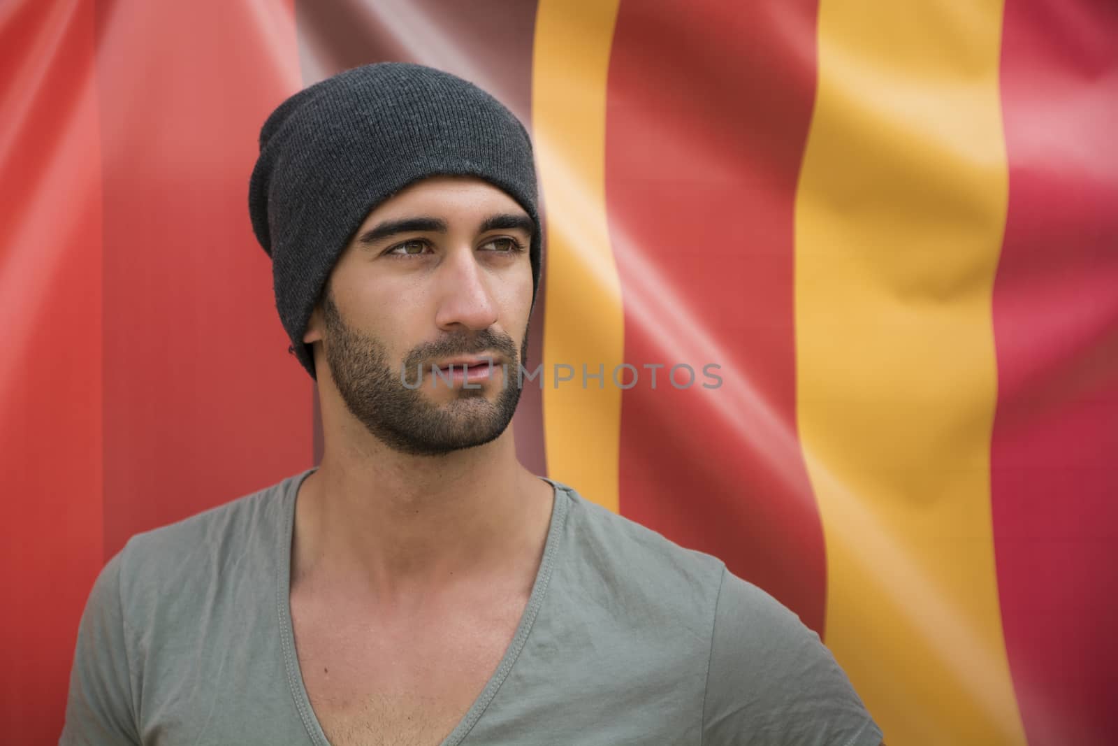 Handsome bearded young man on colorful background, looking away