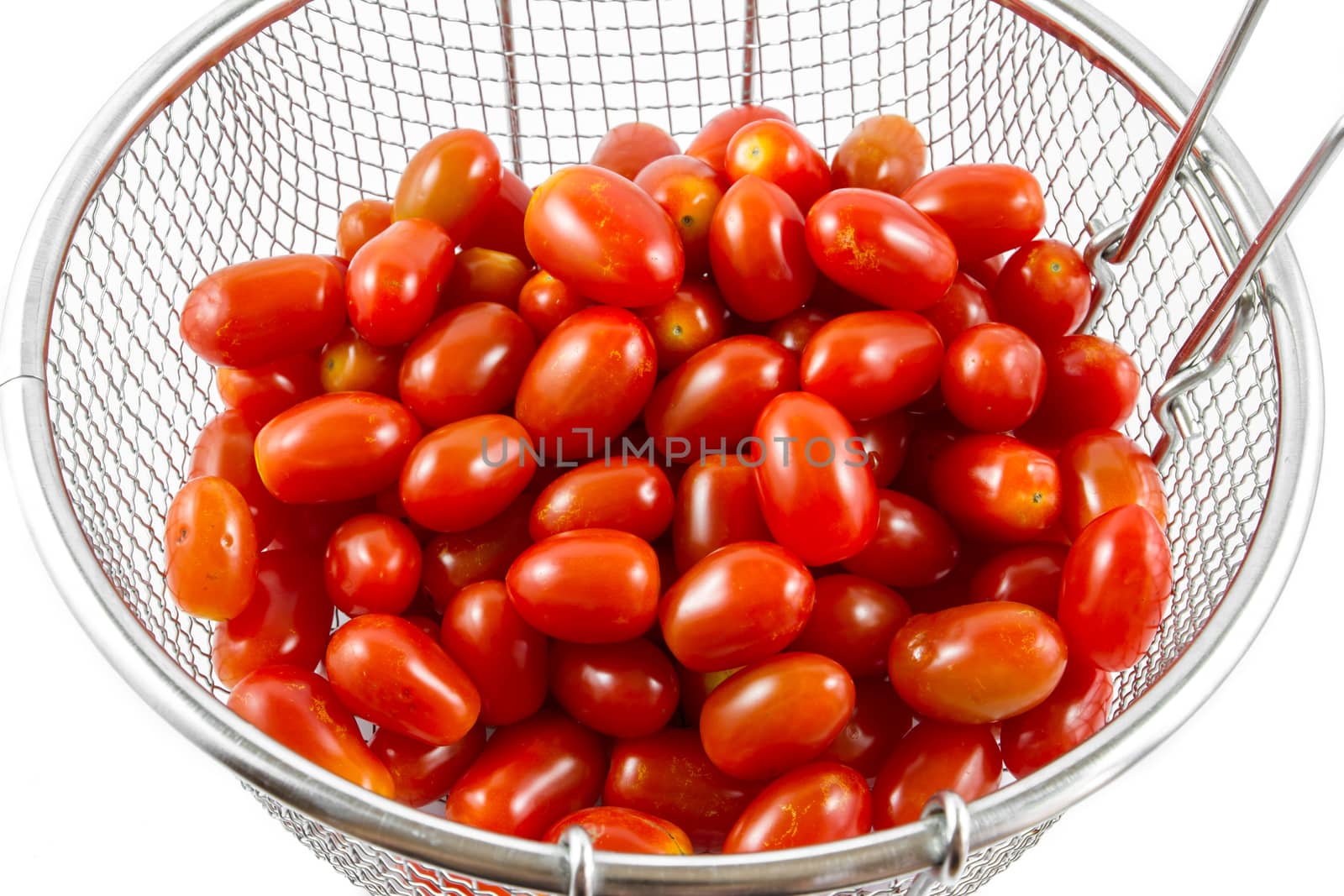 Group of cherry tomatoes in metal basket isolated on white background