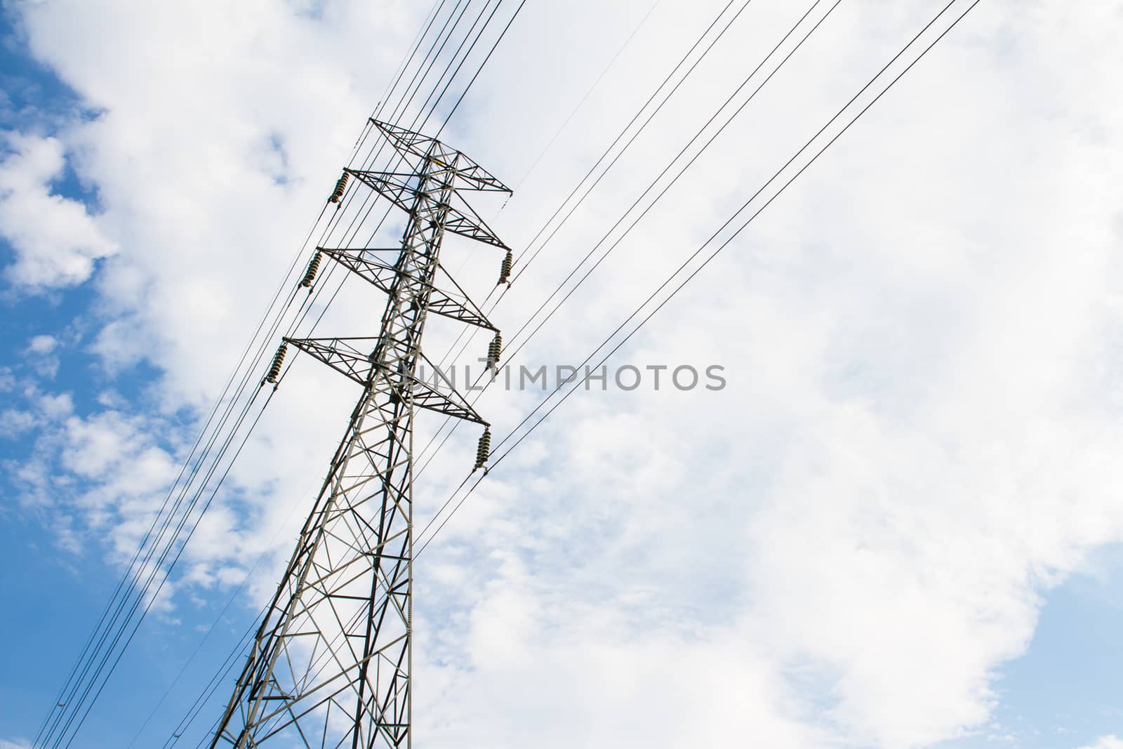 High voltage transmission tower in blue sky background