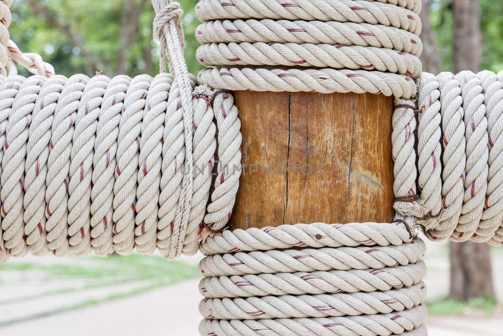 Closeup view of rope tied around wooden pillar