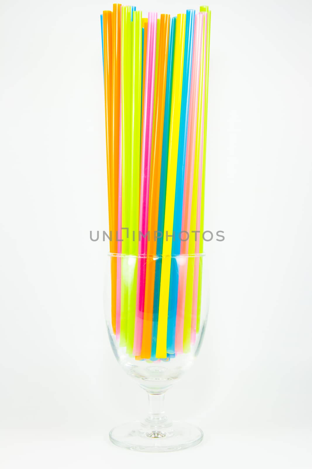 Colorful drinking straws in glass isolated on white background by kasinv