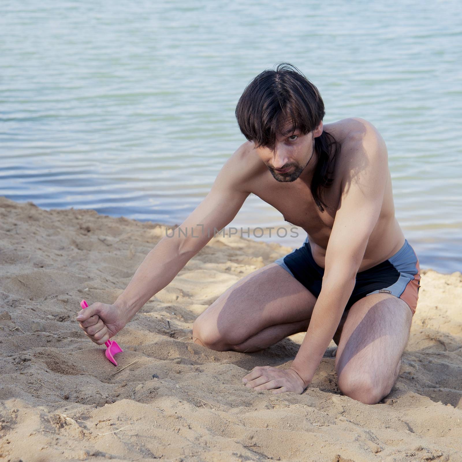 man in a bathing suit on the beach in the sand in the summer