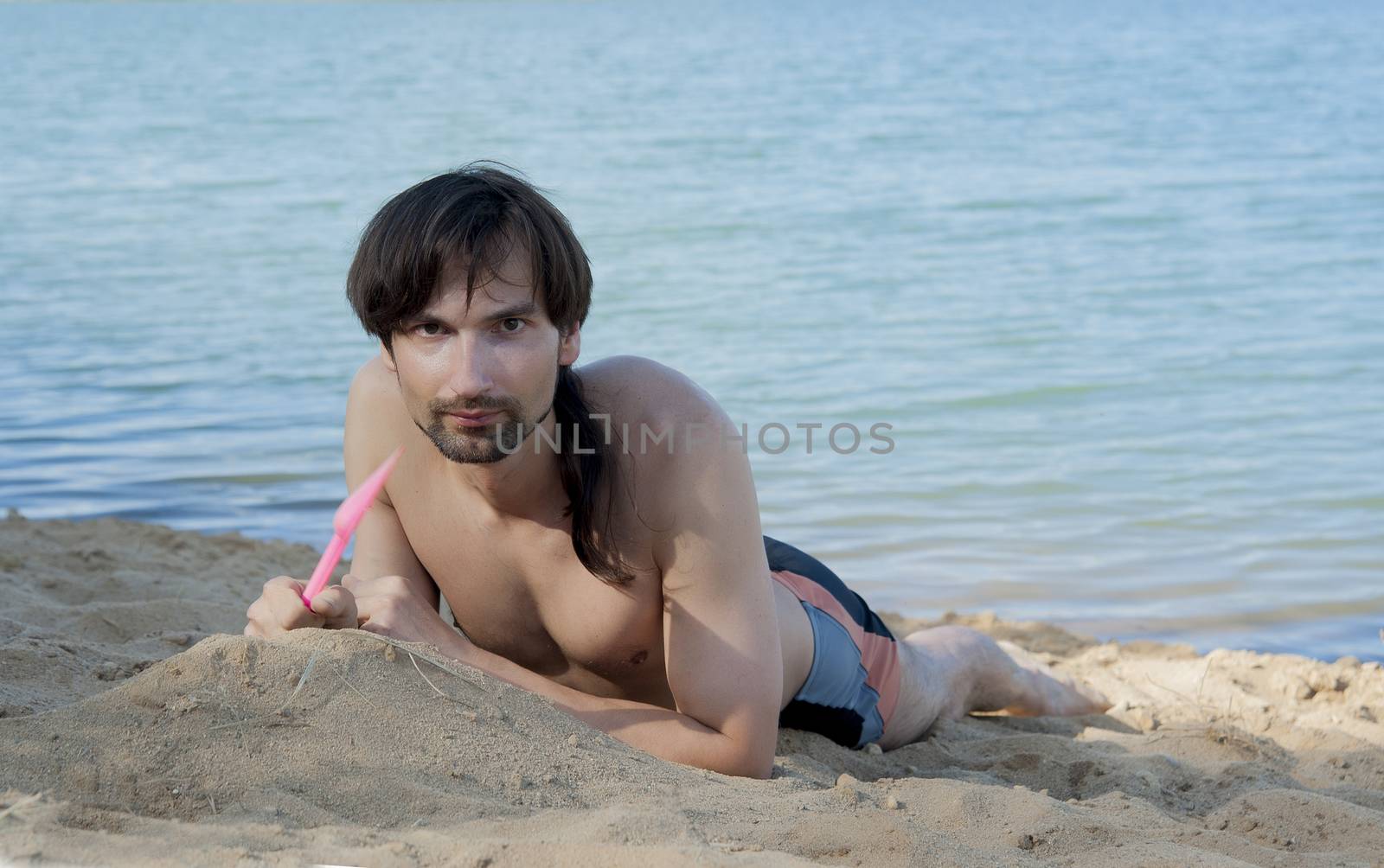 man in a bathing suit on the beach in the sand in the summer