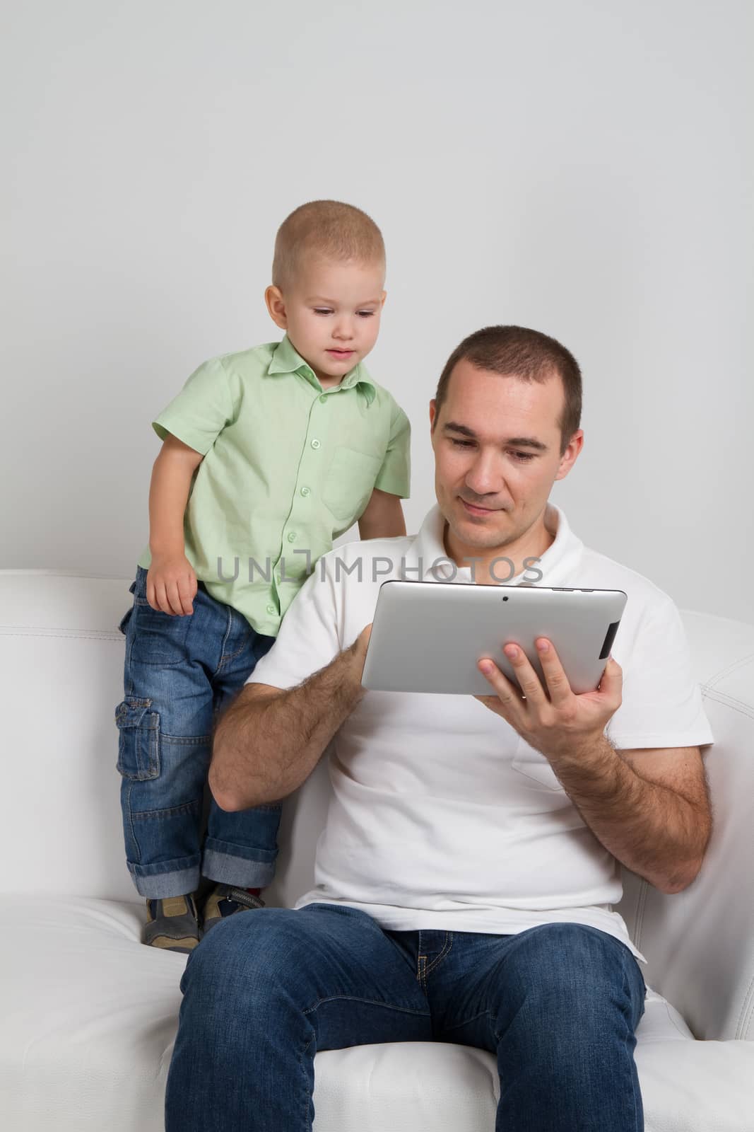 Dad and son watching tablet by Marina_Po