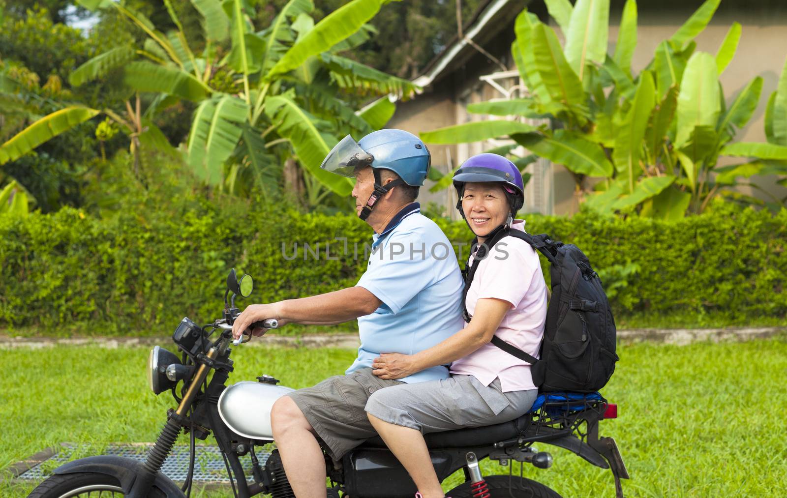 asian senior couple driving motorcycle to travel by tomwang